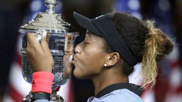 Naomi Osaka kissing hew victory trophy