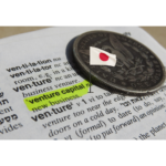 An image of a dictionary entry for "venture capital" with a pin location of the Japan flag showcasing venture capital in Japan.